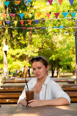 Pretty young girl wearing shorts and a white shirt in the summer park