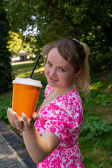 Pretty blonde girl wearing pink and white dress in the park