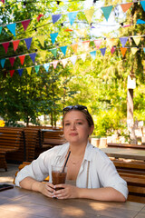 Pretty young girl wearing shorts and a white shirt in the summer park