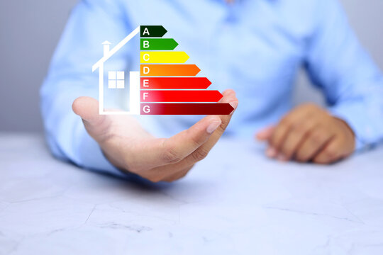 House energy efficiency rating labeling with businessman holding label for reduce reduce energy consumption environmental friendly building concept
