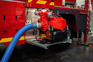 Fototapeta premium Firefighter's Fire Truck Water Pump with Blue Hose Ready for Immediate Action in Case of Fire