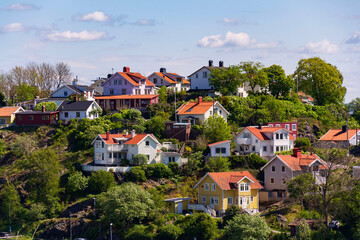 Picturesque colony of old small wooden historic houses on the Slottsberget mountain on the banks of the Gota alv river, Gothenburg, Sweden, sunny day