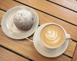 Delicious breakfast - a bun and a cup of cappuccino