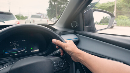 Hand of driving man control the car steering wheel. Interior view of luxury car. Car driving on the road. In fron with other cars. Side with road and green forest. in the day time.