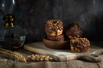 Donuts covered in chocolate on a cutting board