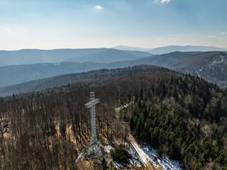 Aerial drone view of beskid mountains in spring. Chrobacz Meadow peak in the Magurka Wilkowicka Group in the Little Beskids. Cross on a mountaintop in the Beskids..