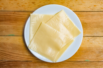 Cheese slices on a plate on a wooden table