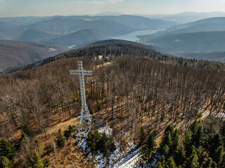 Aerial drone view of beskid mountains in spring. Chrobacz Meadow peak in the Magurka Wilkowicka Group in the Little Beskids. Cross on a mountaintop in the Beskids..