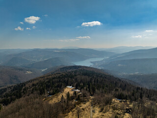 Aerial drone view of beskid mountains in spring. Chrobacz Meadow peak in the Magurka Wilkowicka Group in the Little Beskids. Cross on a mountaintop in the Beskids..