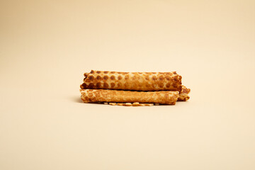 Waffle rolls – front view, beige background, isolated 