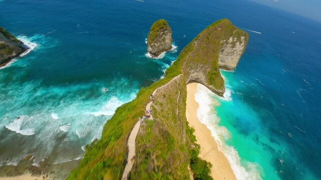 Cinematic FPV drone flight over dramatic cliffs, white sand beach, and turquoise ocean at iconic Kelingking Beach in Nusa Penida, Bali, Indonesia. Ideal for travel, summer, tropical adventure themes.