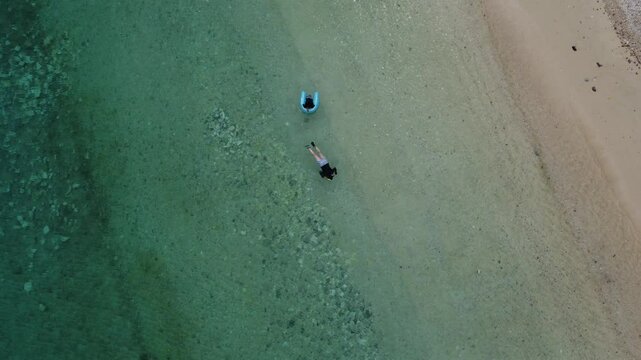 4K The serene seascape of Okinawa showcases crystal-clear waters, exposed rocky formations, and gentle waves lapping against the shore