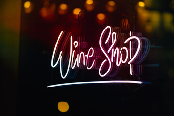 Glowing wine shop neon sign at night on London Street