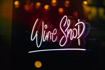 Glowing wine shop neon sign at night on London Street