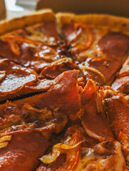 Pizza topped with pepperoni and melted cheese, showing flaky crust and savory toppings.