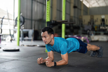 Fototapeta premium Fitness: Man Performing Plank Exercise in Gym