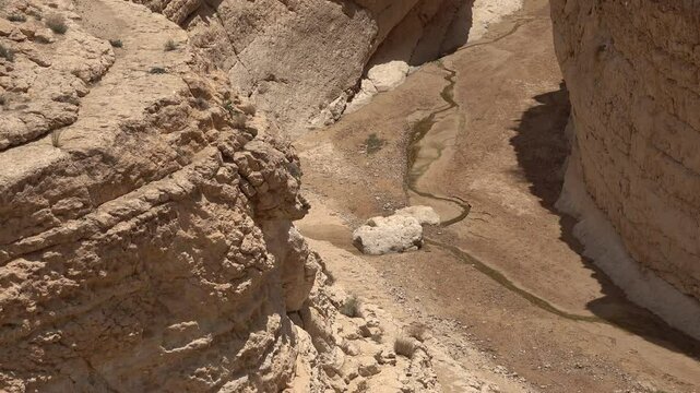 Trickle of water flows through Mides canyon gorge, drought and mountain scenery in Tunisia
