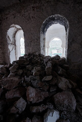 Abandoned Stone Building with Pile of Rubble and Arched Window View..