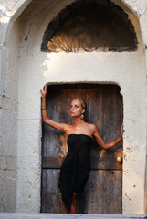 Elegant Woman Posing In Front of an Old Rustic Wooden Door..
