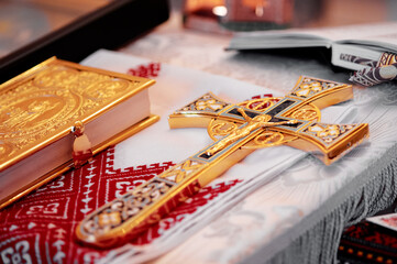 Golden Orthodox cross and Gospel book on embroidered altar cloth.