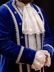 Elegant Man Wearing Ornate Blue Historical Costume with White Lace Details..