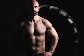 Senior crossfit male athlete posing in front of a Tire