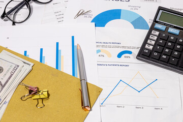 Financial Workspace with Graph Sheets, Calculator, and Cash – Focused View of Business Analysis
