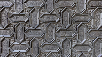 Ornate Islamic geometric pattern carved into a metal surface showcasing intricate craftmanship and...