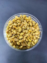 Delicious fried soybean snack. fried soybeans in a plastic jar. top view.
