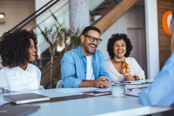 Happy Business Professionals Sharing Laughter During a Casual Office Meeting