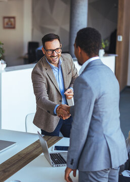 Businessmen Shaking Hands During a Meeting Inside a Modern Office Setting