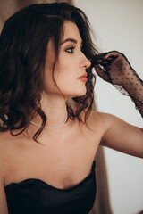 Elegant woman in black dress with polka dot gloves looking aside