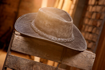 Men's cowboy hat, lying on a crate. This Gallon Hat is brown leather. Mass production. Country music style