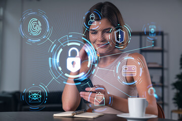 Smiling businesswoman in casual wear holding using smartphone typing at office workplace with notebook. Concept of distant work, business education. Lock icon drawings hologram