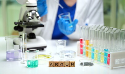 Fototapeta premium A dedicated scientist expertly uses a microscope surrounded by colorful lab solutions and essential laboratory tools