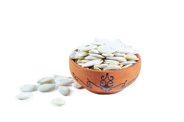 Pile of pumpkin seeds in a clay bowl isolated on a white background.