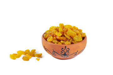 Golden raisins in a clay bowl isolated on white background.