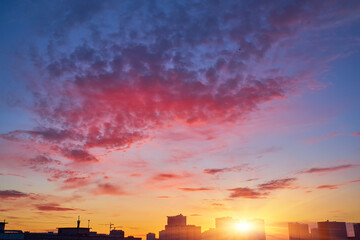 Urban Skyline Silhouette with Cranes at Colorful Dusk