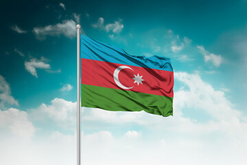 High-resolution stock image of a gently billowing Azerbaijan national flag mounted on a modern...