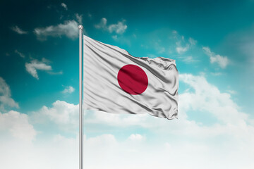 High-resolution stock image of a gently billowing Japan national flag mounted on a modern flagpole...