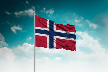 High-resolution stock image of a gently billowing Norway national flag mounted on a modern flagpole...