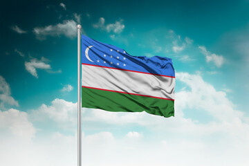 High-resolution stock image of a gently billowing Uzbekistan national flag mounted on a modern flagpole against a dramatic sky backdrop, symbolizing unity, patriotism, and global connection.