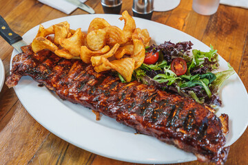 Pork Rib Steak with potato chips and salad