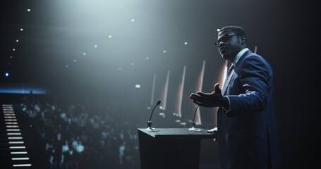 Portrait of an Empowering Thought Leader Standing at a Tribune, Showing an Inspiring Presentation...