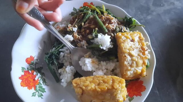 Nasi Pecel, traditional Javanese rice with vegetable vegetables and peanut sauce, served with side dishes