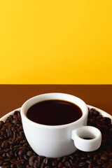 White Cup of Black Coffee with Roasted Beans on Solid Colored Background for Creative Branding