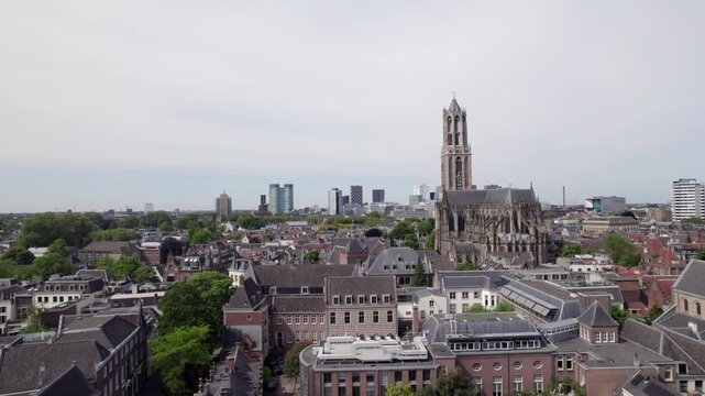 Aerial of gothic cathedral nave and De Dom church tower architecture among historic buildings in Utrecht city center. Dutch Holland religious tourist destination seen from above.