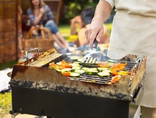 A man is cooking vegetables on a grill