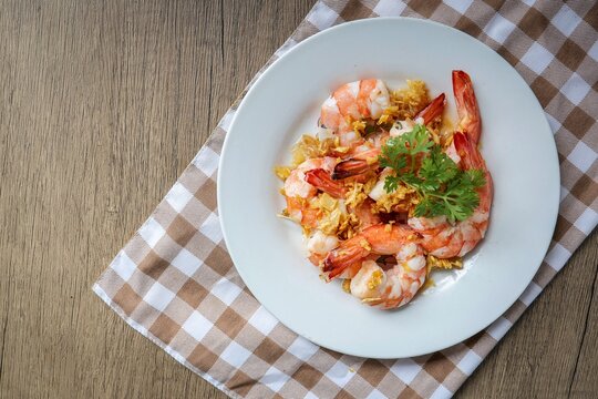 Stir Fried Shrimps with Garlic on white ceramic plate, home cook	
