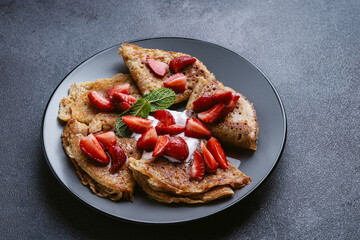 Sweet whole grain crepes with strawberry and sour cream